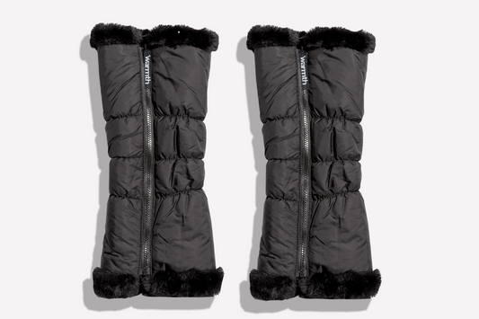 Pair of black puffer leg warmers with zipper pulls with fur trim on a white background